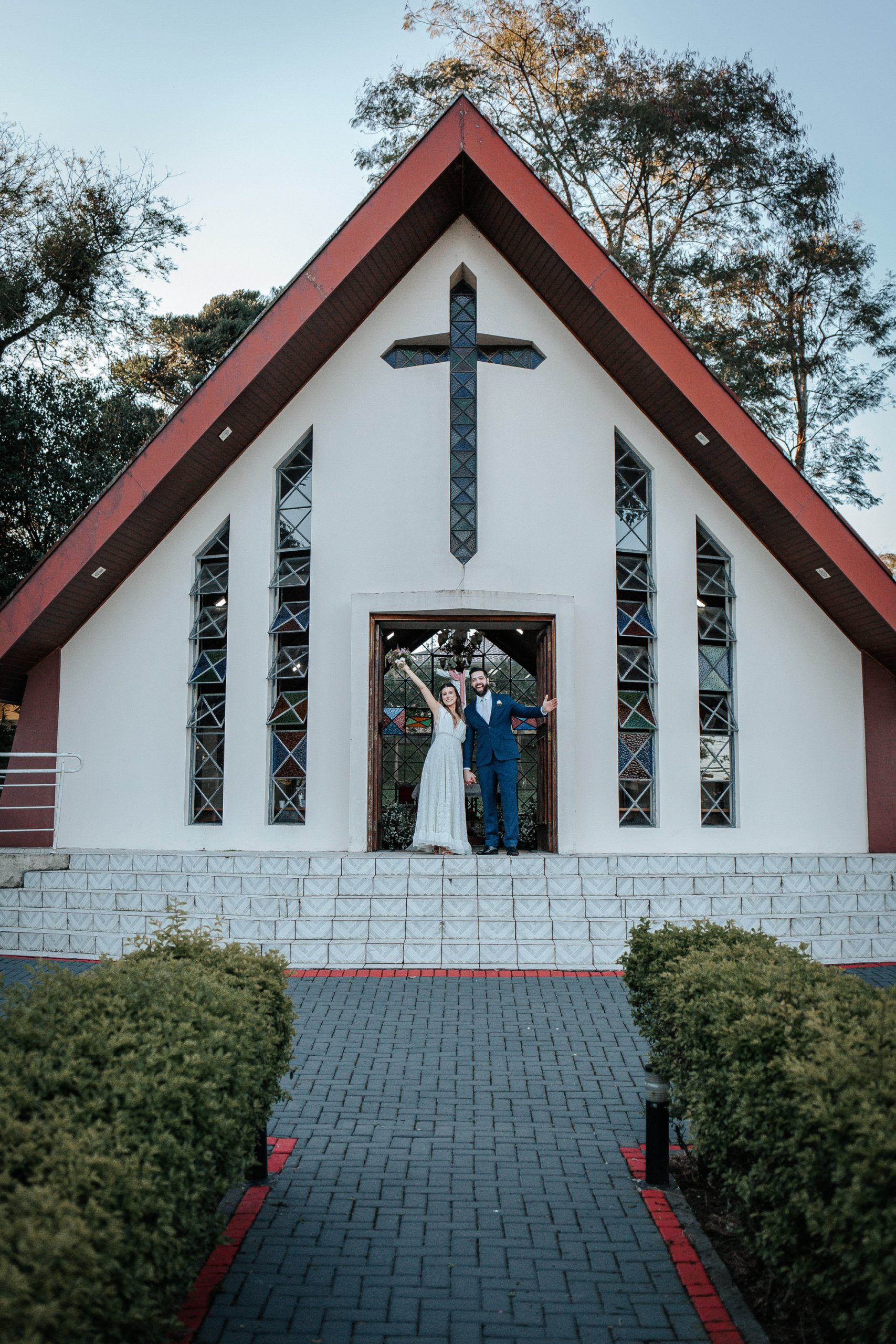 Noivos comemorando a saída da igreja após celebração de mini wedding em Curitiba.