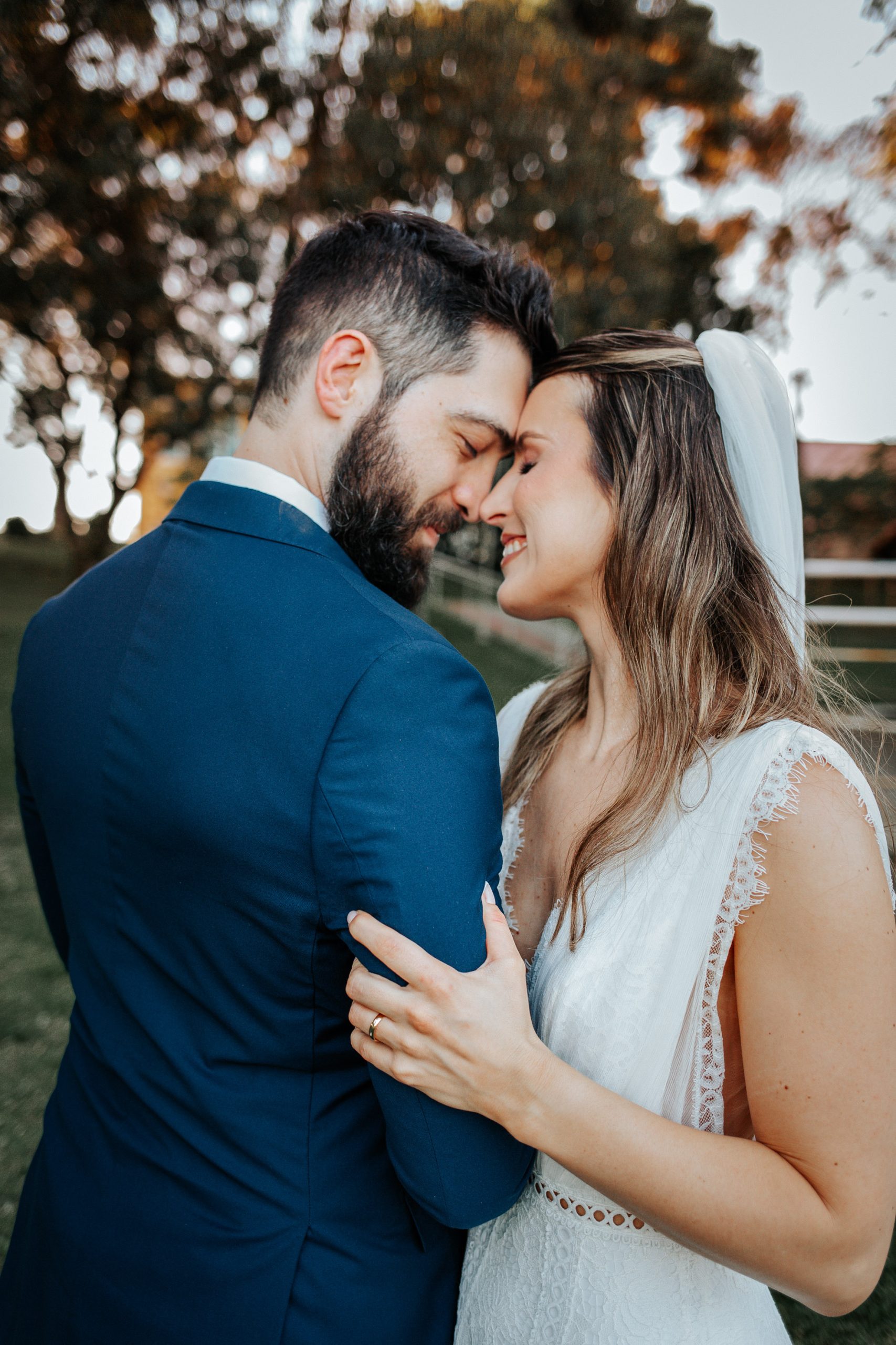 Noivos sorrindo em momento descontraído ao pôr do sol, registrado por fotógrafa de casamento em Curitiba.