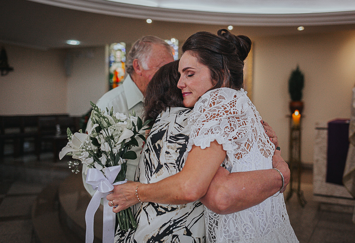 mãe e noiva se abraçando na cerimonia de casamento católica na paróquia Vila Izabel em Curitiba