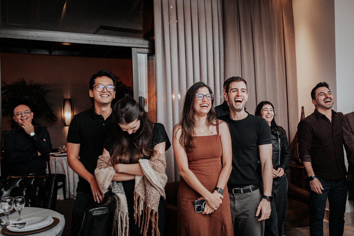 Fotografia espontânea de noivos e padrinhos celebrando em mini wedding.