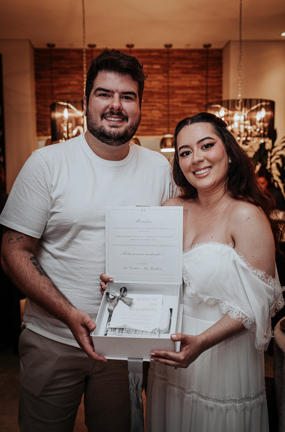 Noivos Ana e Luiz entregando convites personalizados para os padrinhos.