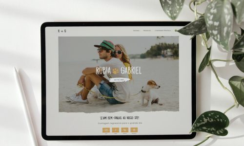 Exemplo de página inicial de um site de casamento do iCasei com lista de presentes mostrando foto de casal na praia com cachorro, contagem regressiva e menu de navegação.